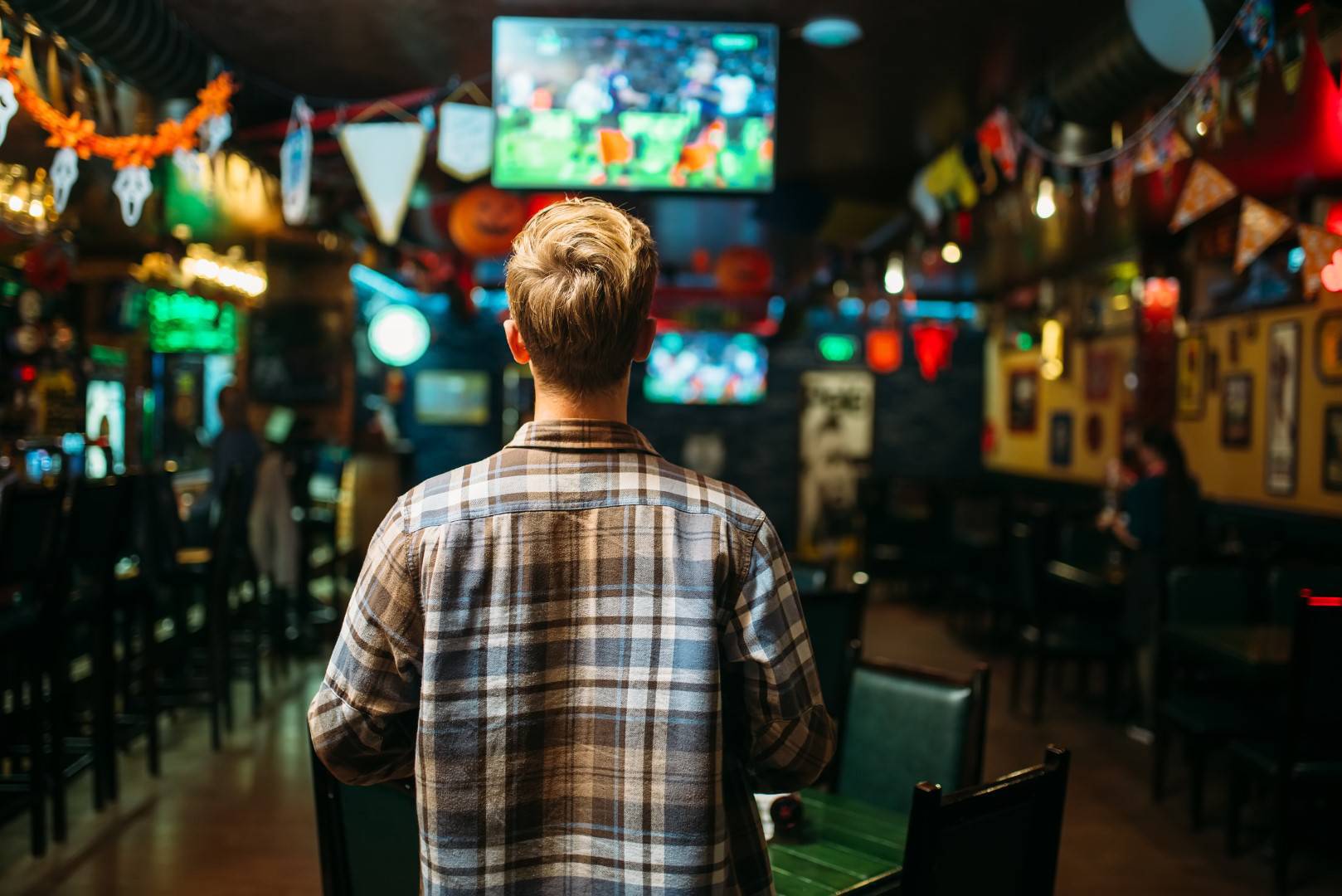 football-fan-watching-match-bar-online-sports-betting-singapore